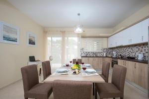 a dining room with a table and chairs in a kitchen at Georgia Sunset in Trákhilos