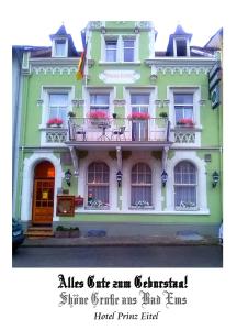 ein grün-weißes Gebäude mit einem Balkon in der Unterkunft Hotel Prinz Eitel in Bad Ems