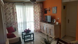 een woonkamer met een bank en een raam bij Erisa I in Torremolinos