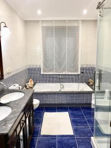 a bathroom with a tub and two sinks and a toilet at Casa Con Piscina Junto Al Mar in Oia