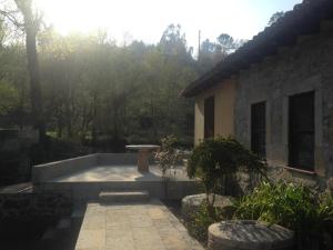 a patio with a bench in front of a house at Moinho das Cavadas in Ponte da Barca