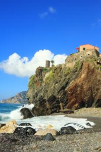a rocky beach with a castle on top of a mountain at vernazza vacation 3 in Vernazza