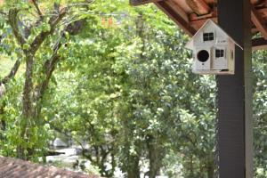 una casa de pájaros al lado de una casa en Pousada Agua Cristalina, en Cachoeiras de Macacu