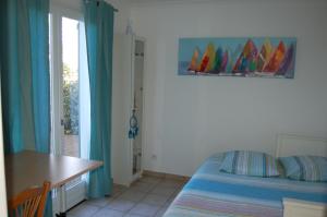 Schlafzimmer mit einem Bett, einem Schreibtisch und einem Fenster in der Unterkunft La Maison de Peggy in Garons