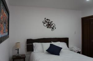 蒂瓦索薩的住宿－San Benito Hotel，一间卧室配有一张带蓝色枕头的床