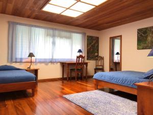 um quarto com 2 camas, uma secretária e uma janela em Casa Cañitas em Monteverde