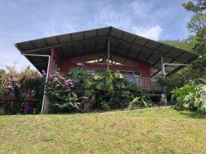 Casa roja con balcón y flores en Casa Cañitas, en Monteverde