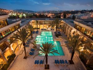 una vista sul soffitto di una piscina con palme e sedie di Dan Jerusalem Hotel a Gerusalemme