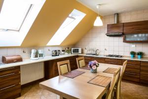 a kitchen with a wooden table and a kitchen with skylights at Agro Nad Stawem in Żukowo