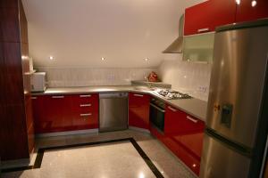 a kitchen with red cabinets and stainless steel appliances at Guesthouse Juka in Gospić