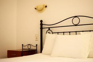 a bed with a black headboard and white pillows at Villa Polyxeni in Sivota