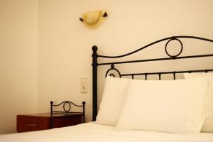 a bed with a black headboard and white pillows at Villa Polyxeni in Syvota