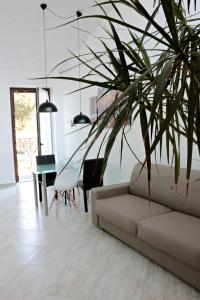 Paradeisos Residence Sas في سوما لومباردو: غرفة معيشة مع أريكة وطاولة