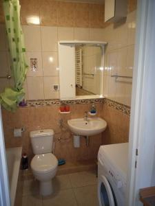 a bathroom with a toilet and a sink and a mirror at ApartamentyPrzyMorzu Reymonta z sypialnią in Kołobrzeg