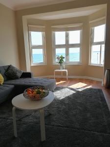 a living room with a couch and a table at Stones Throw From The Beach - Stunning Sea View in Portsmouth