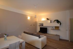 ein Wohnzimmer mit einem weißen Sofa und einem TV in der Unterkunft Uptoyou in Mailand