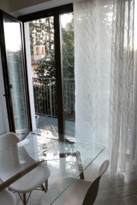 una mesa de cristal y sillas en una habitación con puertas correderas de cristal en Paradeisos Residence Sas en Somma Lombardo