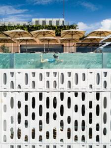 una persona nadando en una piscina con sombrillas en Emiliano Rio, en Río de Janeiro
