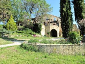 a house with a stone wall in a yard at Le Grand Saint Paul in Rognes