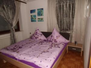uma cama com lençóis e almofadas roxos num quarto em All inkl Card Fewo1-Heigl em Viechtach