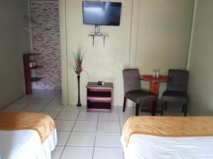 a hotel room with two beds and a tv on the wall at Hotel Boutique Malibu Los Sueños in Tigre