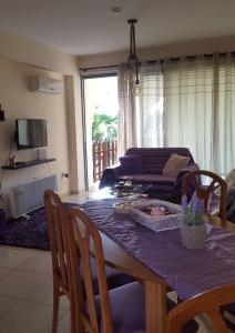 een woonkamer met een tafel en een bank bij Abitare cosy apartment in Paphos City