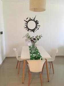una mesa con un jarrón de flores y un espejo en Hermoso departamento con piscina en Río Cuarto