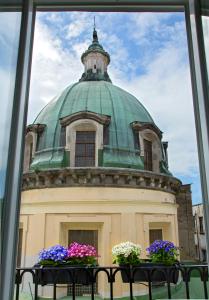 a building with a green dome with flowers in a window at Naplesuite in Naples