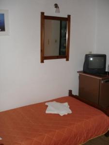 a bedroom with a bed and a mirror and a tv at Elena Beach in Chania