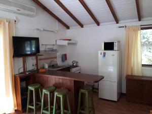 uma cozinha com um balcão com bancos e um frigorífico em Cabañas Del Potrero em Ocean Park
