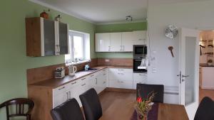 a kitchen with white cabinets and a table with chairs at Ferien-Haus-Leipzig in Leipzig