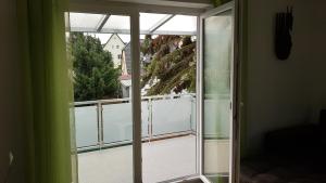 Habitación con puerta corredera de cristal y balcón. en Ferien-Haus-Leipzig en Leipzig