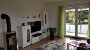 Il comprend un salon doté d'une télévision à écran plat et d'une fenêtre. dans l'établissement Ferien-Haus-Leipzig, à Leipzig