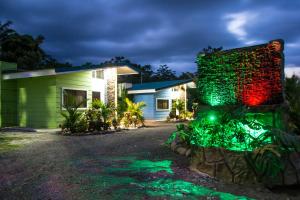 una casa con luces verdes a un lado. en Residencias Arenal, en Fortuna