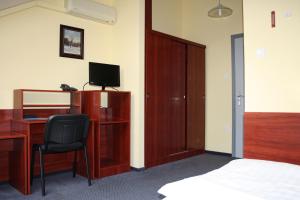a bedroom with a desk and a bed and a chair at Hotel Thelena in Tolna