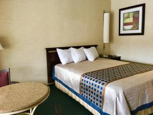 萊文沃思的住宿－River's Edge Lodge，酒店客房配有一张床铺和一张桌子。