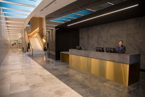 a man sitting at a reception desk in a lobby at Novotel Melbourne South Wharf in Melbourne