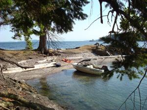 ein Boot am Ufer eines Wasserkörpers in der Unterkunft Sticks and Stones Cottage-Arbutus Grove in Galiano + 11 Fotos