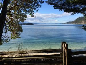 von einem Holzzaun aus Blick auf einen See in der Unterkunft Sticks and Stones Cottage-Arbutus Grove in Galiano