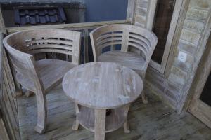 a wooden table and two chairs and a table and a table at Walet's Paradise in Nusa Lembongan