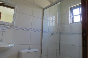 a bathroom with a shower and a toilet and a sink at Chalé no Caborê in Paraty +27 photos