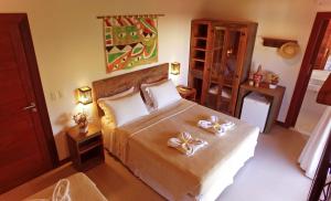 a bedroom with a bed with two bows on it at Pousada João Sol in Praia do Forte