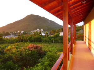 une terrasse couverte d'une maison avec une montagne en arrière-plan dans l'établissement Pousada Mar de Cristal, à Florianópolis