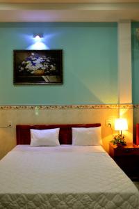 a bedroom with a white bed with a blue wall at Vien Duong Hotel in Quy Nhon