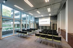 uma sala de conferências com cadeiras e um ecrã num edifício em YHA Mei Ho House Youth Hostel em Hong Kong