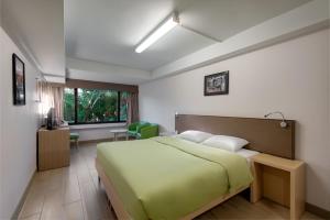 香港的住宿－YHA美荷樓青年旅舍，一间卧室,卧室内设有一张绿色大床