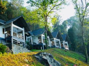 a row of houses on top of a hill at Woodrose Resort in Kalpetta