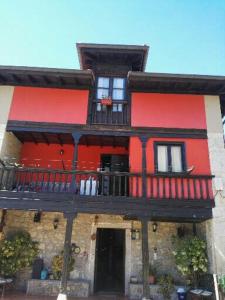 ein rotes und schwarzes Gebäude mit einem Balkon in der Unterkunft Apartamentos El Rincon Encantado in Llano-Con