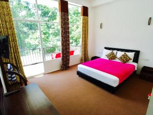 a bedroom with a bed and a large window at Slightly Chilled in Adams Peak