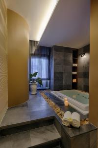 ein großes Bad mit einer Badewanne und einem Fenster in der Unterkunft Belle Maison Parosand Da Nang Hotel -managed by H&K Hospitality in Đà Nẵng
